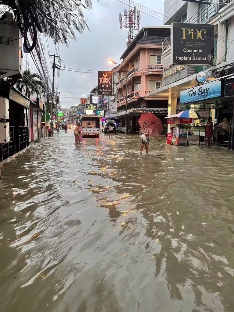 Människor vadar genom översvämmad gata i centrala Pattaya
