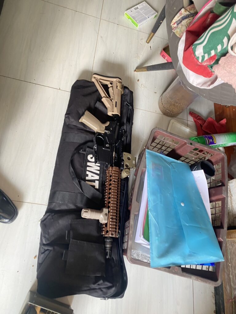 Ljust automatkarbinsliknande vapen liggande pa en svart vapenvaska markt SWAT
