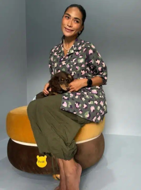 Kvinna sitter med en liten hund i knaet