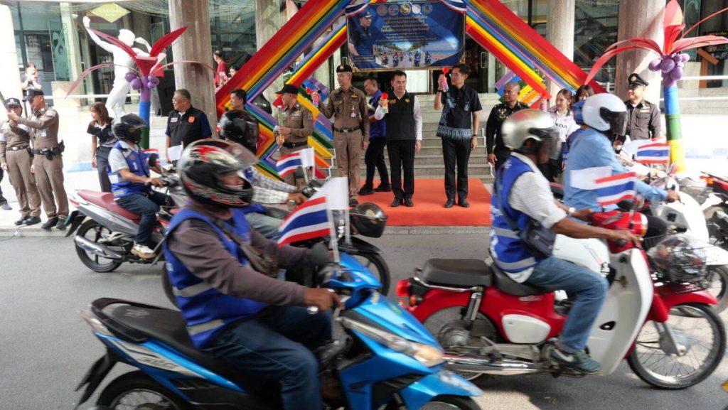 Tjansteman pa en scen medan forare i bla vastar kor forbi