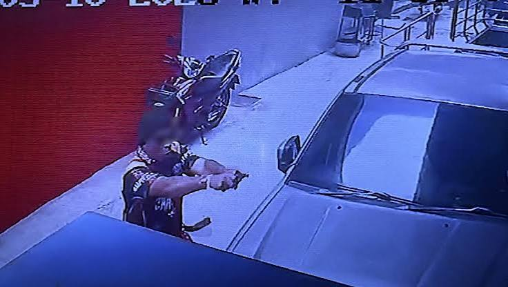 Stillbild ur overvakningsfilm dar en person riktar ett vapen