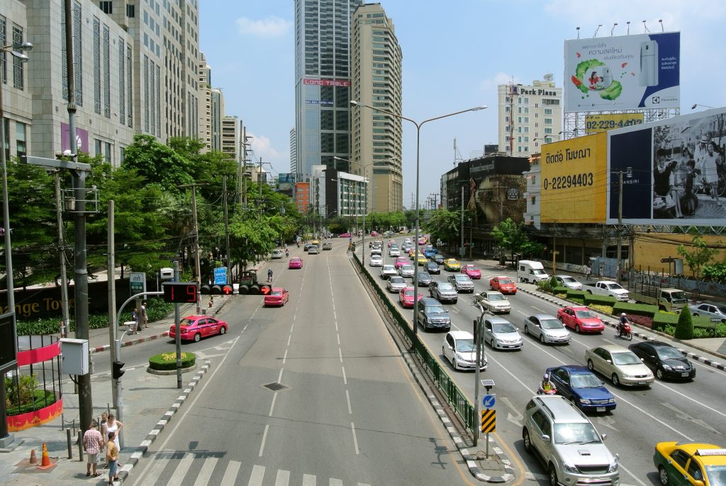 Flerfilig vag i Bangkok med ko av bilar och taxibilar i ena riktningen